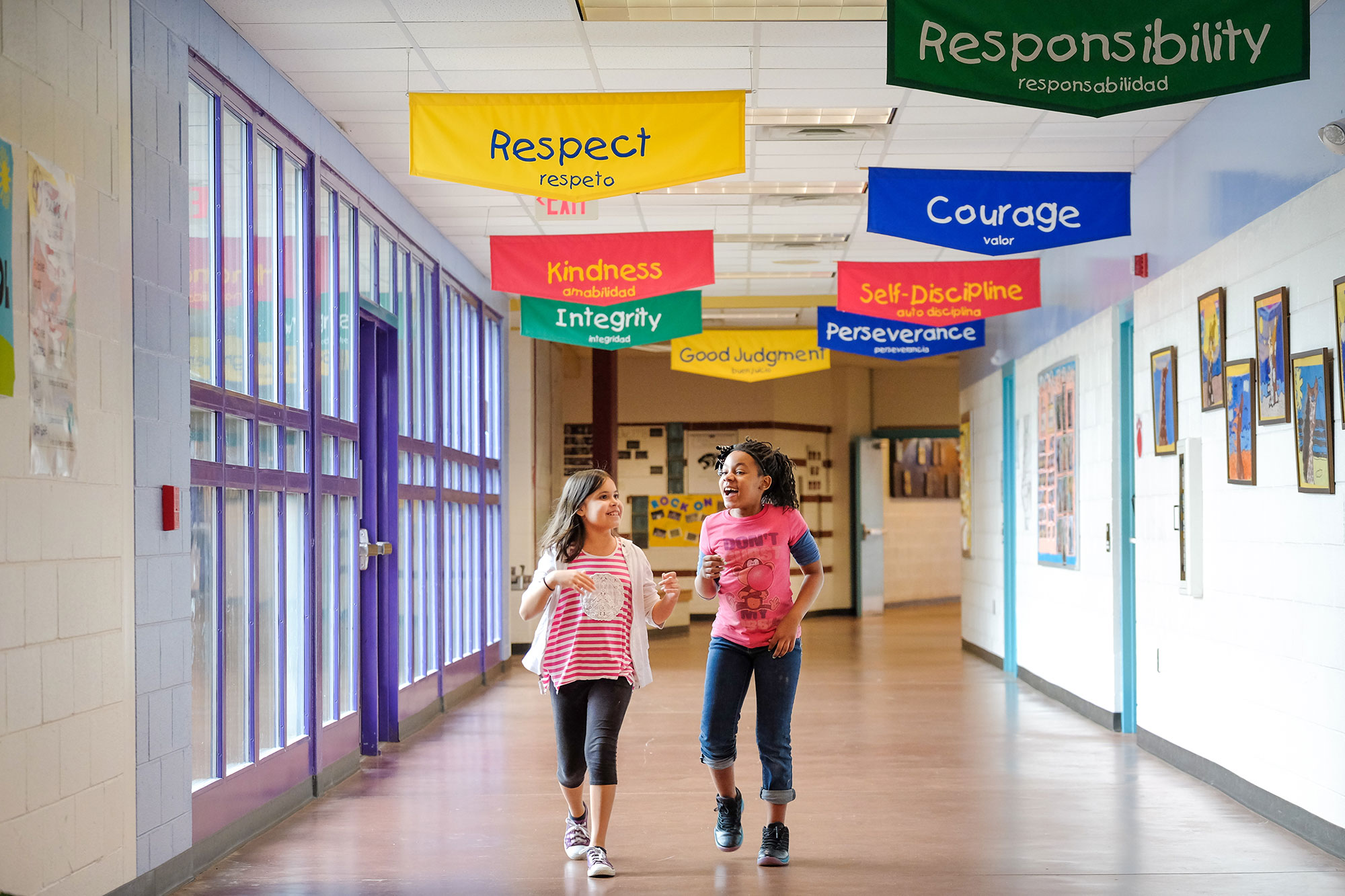 Elementary school students walking past character education banners in hallway